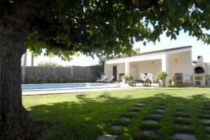 un patio trasero con piscina y una casa en MAS PALOL, en Viladamat