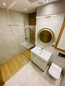 een badkamer met een wastafel, een douche en een toilet bij Górski Apartament Olimpijska 1L in Szczyrk