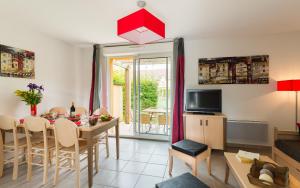 a kitchen and living room with a table and chairs at Lagrange Vacances Les Bastides de Lascaux in Montignac