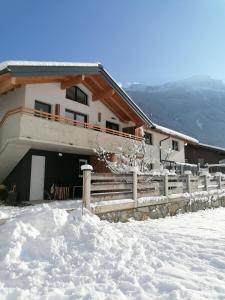 una casa con nieve delante en Bergblick Apartment, en Wald im Pinzgau