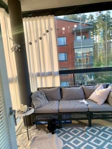 a couch in a room with a large window at Cozy Aparment with sauna nearby Airport in Vantaa