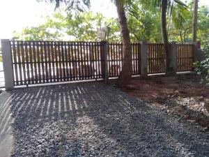 una valla de madera con un árbol en un patio en Surf Villa Hiriketiya en Matara