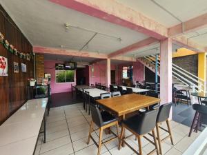 a dining room with a wooden table and chairs at Kupi-Kupi & Stay in Kampong Kundassan