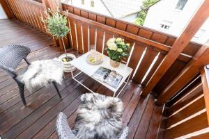 a dog sitting on a deck with a table at Feldmochinger Hof in Munich