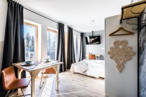 Pokój ze stołem i łóżkiem oraz sypialnią w obiekcie Apartament Sova w mieście Kościelisko