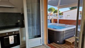 een bad in een keuken met uitzicht op een patio bij rêve méditerranéen, Le bonheur est dans ma maison in Le Barcarès