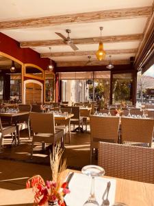 Hotel Restaurant L'Europe في سانت فلوران: غرفة طعام مع طاولات وكراسي وطاولة