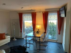 a living room with a glass table and two windows at Kaeppler-Hof-Wieners in Olsberg