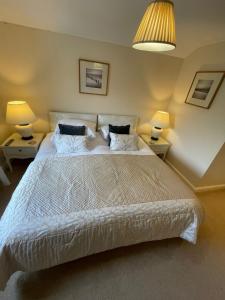 a bedroom with a large white bed with two lamps at Cocketts Hotel in Hawes