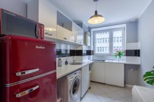 a kitchen with a red refrigerator and a washing machine at ClickTheFlat Żurawia Street Apart Rooms in Warsaw