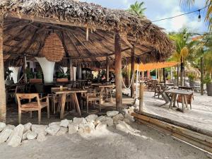 a restaurant with tables and chairs and a straw umbrella at Tip! Blue Bay Beachvilla 12 - Blue Bay Resort in Sint Michiel