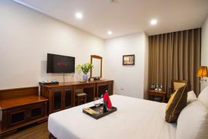 a hotel room with a bed and a flat screen tv at Western Hanoi Hotel in Hanoi