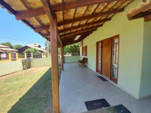 a porch of a house with a wooden pergola at Casa Barra da Ibiraquera in Imbituba