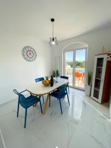 a dining room with a table and blue chairs at Sea View Apartment Amaro in Korčula