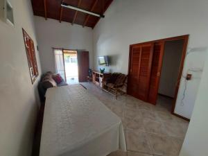 um quarto com uma mesa e uma sala de estar em Casa Barra da Ibiraquera em Imbituba