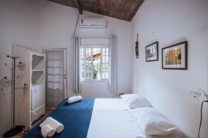una camera da letto con un grande letto con due asciugamani di Maruja a Ilhabela