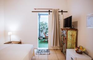 um quarto com uma cama e uma porta de vidro deslizante em Maruja em Ilhabela