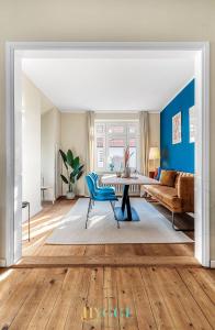 ein Wohnzimmer mit einem Tisch und einem blauen Stuhl in der Unterkunft Villa Hygge Kappeln - Ferienwohnungen in Kappeln