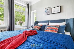 a bedroom with a blue bed with a red scarf on it at Villa Hygge in Kappeln - Design Ferienwohnungen mit Saunawagen in Kappeln