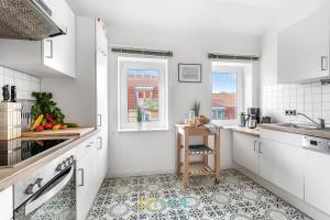 a kitchen with white cabinets and a table in it at Villa Hygge in Kappeln - Design Ferienwohnungen mit Saunawagen in Kappeln