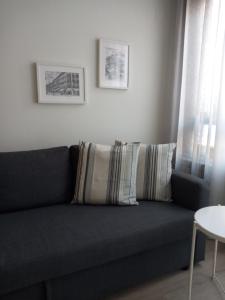 un sofá azul con almohadas en la sala de estar en LA TERRAZA DE LA VEGA - Ubicación inmejorable , wifi , terraza y parking gratuito, en Oviedo