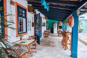 een patio met tafels en stoelen en kleurrijke muren bij Maruja in Ilhabela