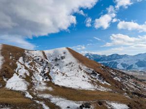 Une montagne enneigée avec des montagnes en arrière-plan dans l'établissement Gudauri Twins Beauty 239, à Goudaouri