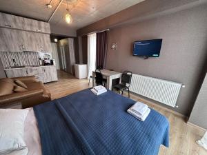 une chambre avec un lit, un bureau et une télévision dans l'établissement Gudauri Twins Beauty 239, à Goudaouri