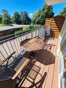 una terraza con mesa de madera y sillas en una casa en Meeresbrise, en Zingst