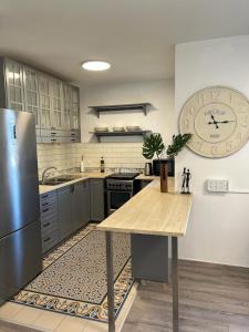 a kitchen with a table and a clock on the wall at Blue Sea Suite in Ashqelon