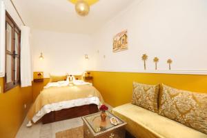馬拉喀什的住宿－Riad Heklek，一间卧室配有一张床和一张沙发