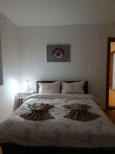 a bedroom with a large bed with two pillows at Apartmani Mir A2 in Vrnjačka Banja