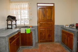 eine Küche mit einem Waschbecken und einer Holztür in der Unterkunft Jenna stays in Nyeri