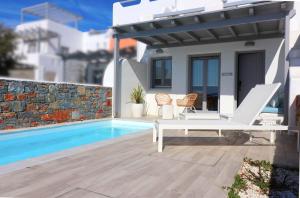 una villa con piscina e patio con due sedie e una vill di The Nine Graces - Agia Anna - Option With private pool or hot tub ad Agia Anna Naxos