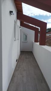 Habitación con paredes blancas y suelo de madera. en SulSeixe Guesthouse, en Odeceixe