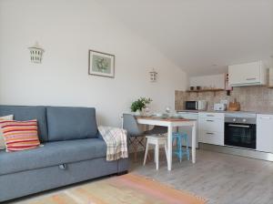 a living room with a blue couch and a kitchen at SulSeixe Guesthouse in Odeceixe