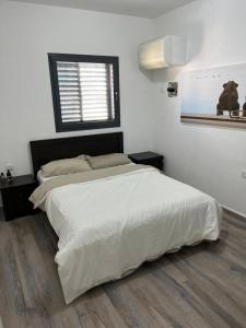 Un dormitorio con una gran cama blanca y una ventana en Blue Sea Suite en Ashqelon