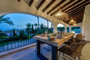 ein Esszimmer mit Tisch und Stühlen und einem großen Fenster in der Unterkunft EL TORO - By Almarina Villas in Benissa