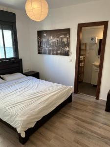 a bedroom with a bed and a picture of a city at Blue Sea Suite in Ashkelon