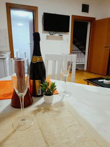 a bottle of champagne and two wine glasses on a table at Apartmani Mir A2 in Vrnjačka Banja