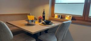 una mesa de comedor con una botella de vino y sillas en Apart Antonius, en Pfunds