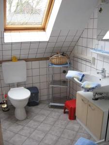 a bathroom with a toilet and a sink and a window at Ferienwohnung-Roock in Oevenum