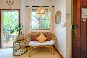 a room with a wicker chair and a window at Villa Siam Lanna at Kantiang Bay in Ko Lanta