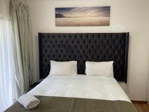 1 dormitorio con 1 cama grande y cabecero negro en luxury with power backup, en Johannesburgo