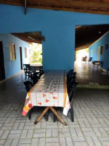 a table and chairs in a room with a blue wall at Mar&cia chácara temporada in São Sebastião