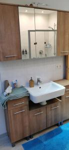 een badkamer met een witte wastafel en een spiegel bij Linda in Ruderatshofen