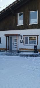 una casa con una entrada cubierta de nieve delante de ella en Linda, en Ruderatshofen