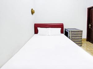 a white bed with a red headboard in a room at SPOT ON 91982 Dani Homestay in Narmada