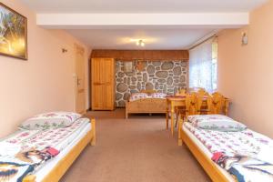 een kamer met twee bedden en een tafel en stoelen bij Leśna Ostoya in Białka Tatrzanska