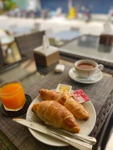 einen Teller Croissants und eine Tasse Kaffee auf dem Tisch in der Unterkunft The Little Moon Residence in Patong Beach